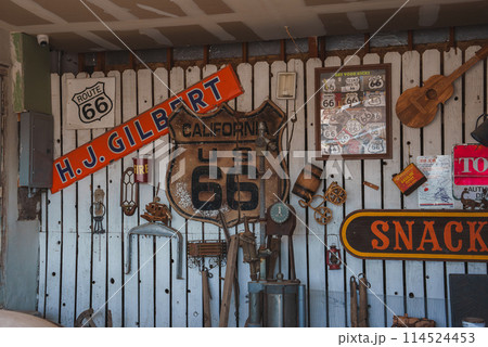 Vintage Americana collection featuring iconic Route 66 memorabilia, including road signs, antique tools, and nostalgic items at a location in Barstow, USA. 114524453