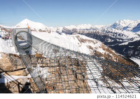 Experience stunning views at Murren ski resort, Switzerland. Walk out on a secure metal walkway with a mesh floor to witness majestic Swiss Alps scenery. Experience stunning views at Murren ski resort, Switzerland. Walk out on a secure metal walkway with a mesh floor to witness majestic Swiss Alps scenery. 114524621