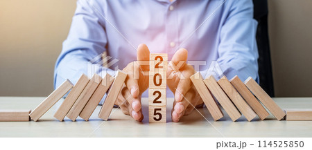 Businessman hand Stopping Falling of 2025 wooden Blocks. Business, Risk Management, Insurance, Resolution, strategy, solution, goal, New Year New You and happy holiday concepts Businessman hand Stopping Falling of 2025 wooden Blocks. Business, Risk Management, Insurance, Resolution, strategy, solution, goal, New Year New You and happy holiday concepts 114525850