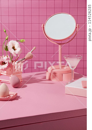 Advertising photo with pink color theme, accessories neatly arranged on cabinet top against pink checkered background. Blank space for design, front view 114526285