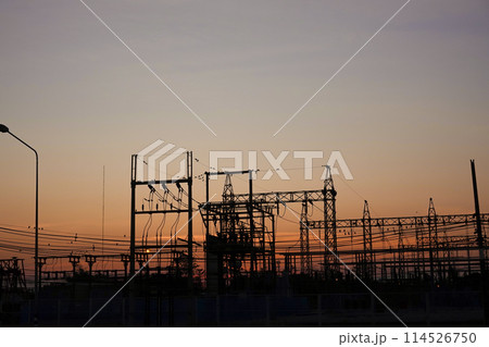 Silhouetted high-voltage electric tower in the dramatic sunset sky 114526750
