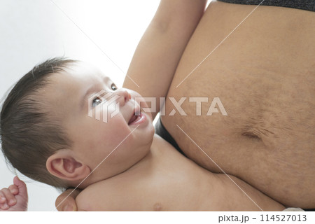産後の妊娠線が残る女性のお腹と笑顔で抱っこされるハーフの男の子の赤ちゃん 産後の妊娠線が残る女性のお腹と笑顔で抱っこされるハーフの男の子の赤ちゃん 114527013