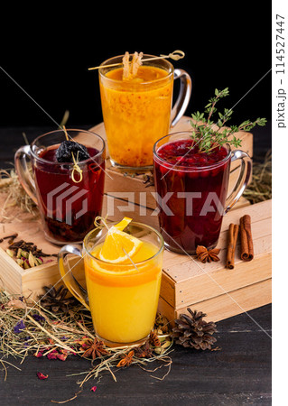 Vertical image of fruit tea ceremony with orange, cinnamon and berries at wooden table background. 114527447