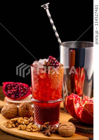 Verical image of glass of homemade pomegranate lemonade at decorated wooden table background. Verical image of glass of homemade pomegranate lemonade at decorated wooden table background. 114527481