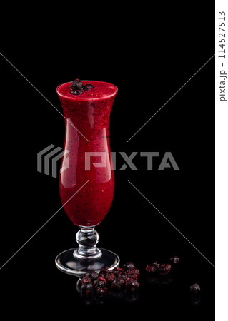 Glass of red currant berries fresh shake decorated with black currant isolated at black background. 114527513
