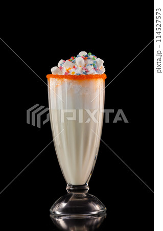 Glass of tasty sweet milkshake decorated with marshmallow isolated at black background. Glass of tasty sweet milkshake decorated with marshmallow isolated at black background. 114527573