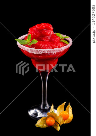 Closeup glass of red daiquiri strawberry cocktail decorated with mint and physalis isolated at black background. 114527608