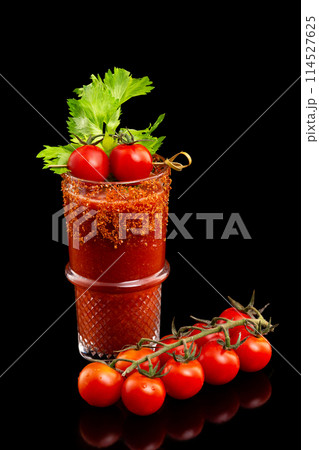 Glass of fresh red tomato juice decorated with celery and pepper isolated at black background. 114527625