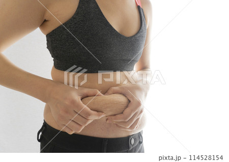 産後の妊娠線が残るお腹の肉をつまむ女性 産後の妊娠線が残るお腹の肉をつまむ女性 114528154