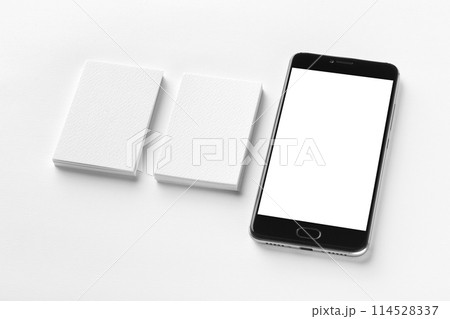 Mockup of two vertical business cards and black cell-phone with blank screen at white textured paper background. Mockup of two vertical business cards and black cell-phone with blank screen at white textured paper background. 114528337