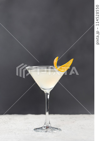 Glass of clear margarita cocktail served with lemon at grey background with copyspace 114528550