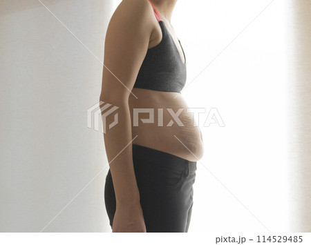 産後の妊娠線が残る猫背の女性のお腹 114529485