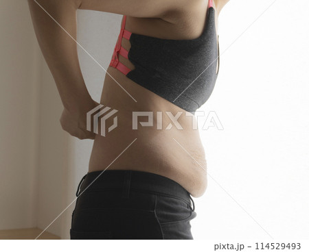 腰に手をあてる産後の妊娠線が残るお腹の女性 腰に手をあてる産後の妊娠線が残るお腹の女性 114529493