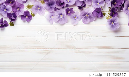 Upper border of beautiful small violet flowers on wooden white background, copy space. 114529827