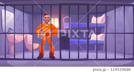 Male prisoner standing behind bars in prison. 114529886