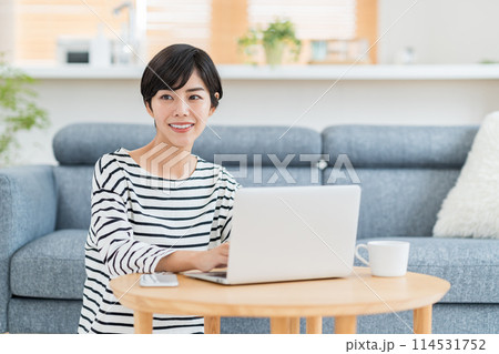 リビングでパソコンを使う女性。 114531752