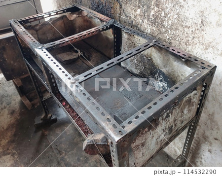 The iron table that houses the trader's stove looks dirty, the table has been used for annual trading 114532290