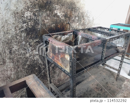 The iron table that houses the trader's stove looks dirty, the table has been used for annual trading 114532292