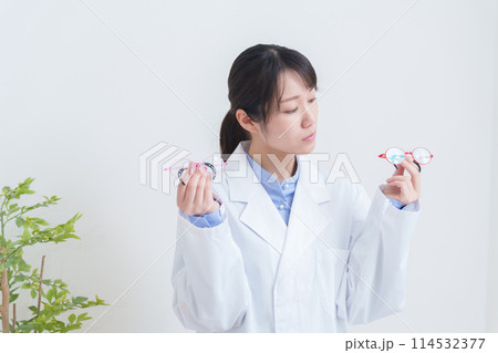 子供の弱視用眼鏡を持つ眼科医 114532377