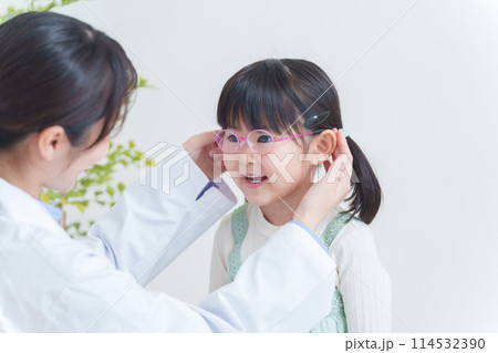 眼科医と眼鏡をかけた弱視の子供 114532390