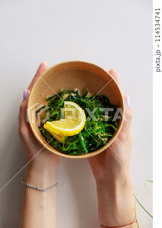 Hiyashi Wakame Salad In Kraft Food Delivery Container In Female Hands, Chuka Salad 114534741