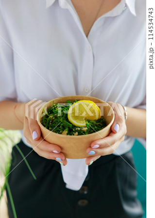Hiyashi Wakame Salad In Kraft Food Delivery Container In Female Hands, Chuka Salad 114534743