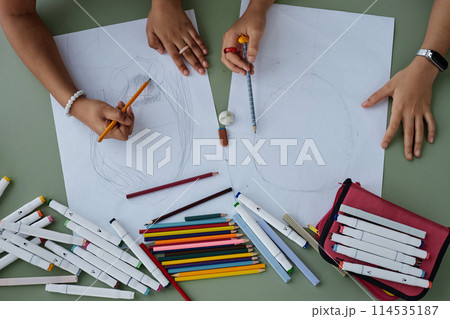 Top view two unrecognizable Black girls drawing pictures together at table, copy space Top view two unrecognizable Black girls drawing pictures together at table, copy space 114535187