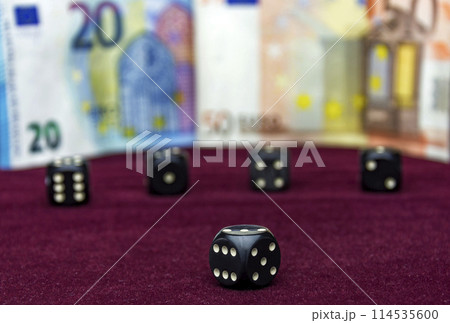 On the red velvet clearly visible black cube. In the background, without the focus of four cubes and banknotes visible On the red velvet clearly visible black cube. In the background, without the focus of four cubes and banknotes visible 114535600