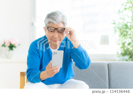 スマホの画面が見づらいシニア男性 114536448