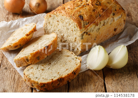 Traditional loaf of onion bread sliced close-up on parchment. Horizontal 114538178
