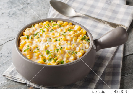 Creamy corn with cream, milk and grated parmesan closeup on the bowl. Horizontal Creamy corn with cream, milk and grated parmesan closeup on the bowl. Horizontal 114538192
