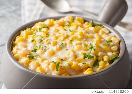 Sweet corn with rich cream, butter, parmesan cheese closeup on the bowl. Horizontal Sweet corn with rich cream, butter, parmesan cheese closeup on the bowl. Horizontal 114538200