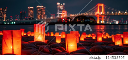 A beachfront aglow with the light of lanterns under a deep twilight sky, celebrating Marine Day with Tokyos iconic bridge and skyline in view. Japanese Umi no Hi also known as Ocean Day or Sea Day 114538705
