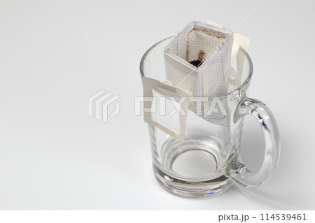 Brew Ground Coffee Using instant Paper Type Filter, Drip Coffee Bag in a Cup, Brewing coffee in a glass with a drip bag. Brew Ground Coffee Using instant Paper Type Filter, Drip Coffee Bag in a Cup, Brewing coffee in a glass with a drip bag. 114539461
