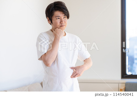 皮下脂肪をつまんで考え込む男性 皮下脂肪をつまんで考え込む男性 114540041