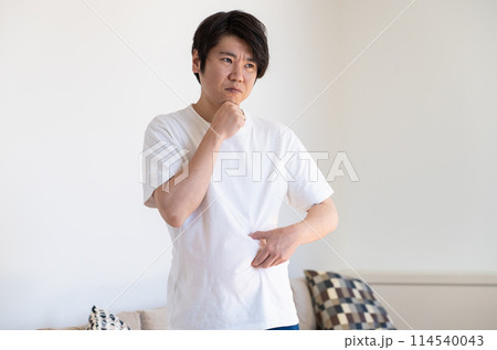 皮下脂肪をつまんで考え込む男性 皮下脂肪をつまんで考え込む男性 114540043