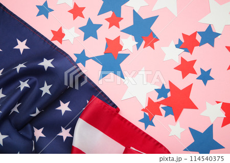 White, blue and red decorations to celebrate July 4th. American flag with paper star on pink background. White, blue and red decorations to celebrate July 4th. American flag with paper star on pink background. 114540375