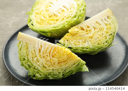 Fresh cut cabbages on dark plate on grey background 114540414