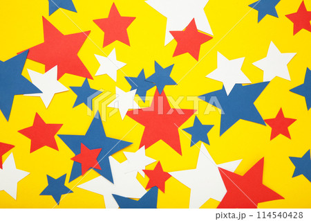 American independence day, celebration, patriotism and holidays concept - red, white and blue paper stars on yellow background. 114540428