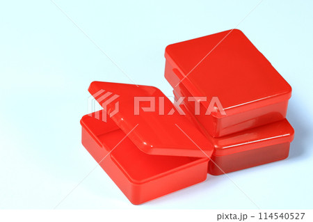 Small transparent red plastic boxes isolated on white background. Small transparent red plastic boxes isolated on white background. 114540527