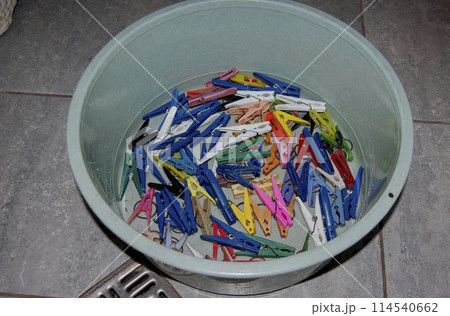 Linen bowl with clothespins.Lots of colorful clothespins in a bowl. Linen bowl with clothespins.Lots of colorful clothespins in a bowl. 114540662