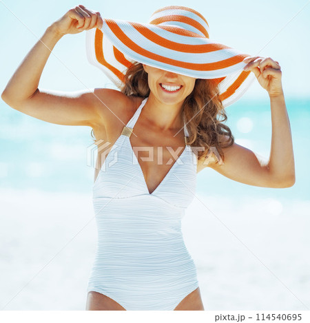 smiling young woman in hat on beach 114540695