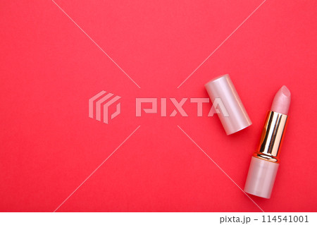 Nude lipstick on red background, close up 114541001