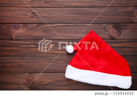 Santa Claus red hat on brown wooden background 114541035