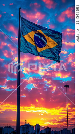 vibrant flag of Brazil dances in the sky as the sun sets, symbolizing strength, unity, and patriotism. 114542695
