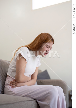 Asian woman having painful from stomach ache at home, Female suffering with abdominal pain Asian woman having painful from stomach ache at home, Female suffering with abdominal pain 114543293