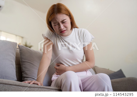 Asian woman having painful from stomach ache at home, Female suffering with abdominal pain 114543295