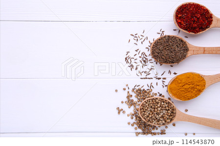 Spices mix on wooden spoons on a white wooden background. Top view Spices mix on wooden spoons on a white wooden background. Top view 114543870