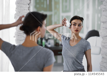Facial skin care. A woman is doing a face massage using a massager that passes micro current. Facial skin care. A woman is doing a face massage using a massager that passes micro current. 114545543