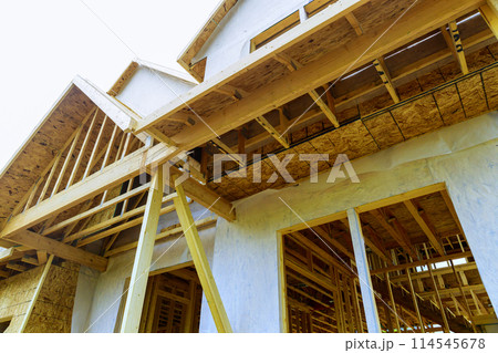 There is joist framework with plywood installed, gutter holders trim installed on soffit fascia house that is under construction 114545678